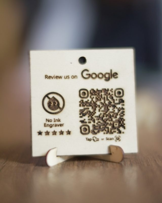 Laser-engraved Google Review plaque with QR code on a wooden stand