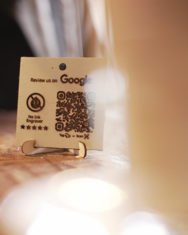 Engraved wooden review plaque on a cafe table